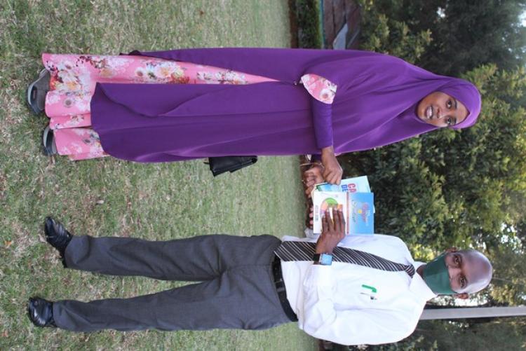 A student receives  books from Mr Kanja